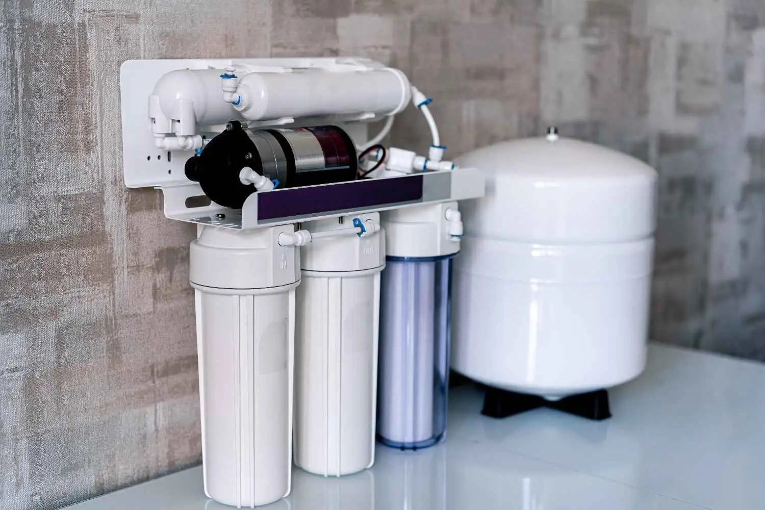 Reverse osmosis water filtration system with multiple filter cartridges and storage tank installed under kitchen sink