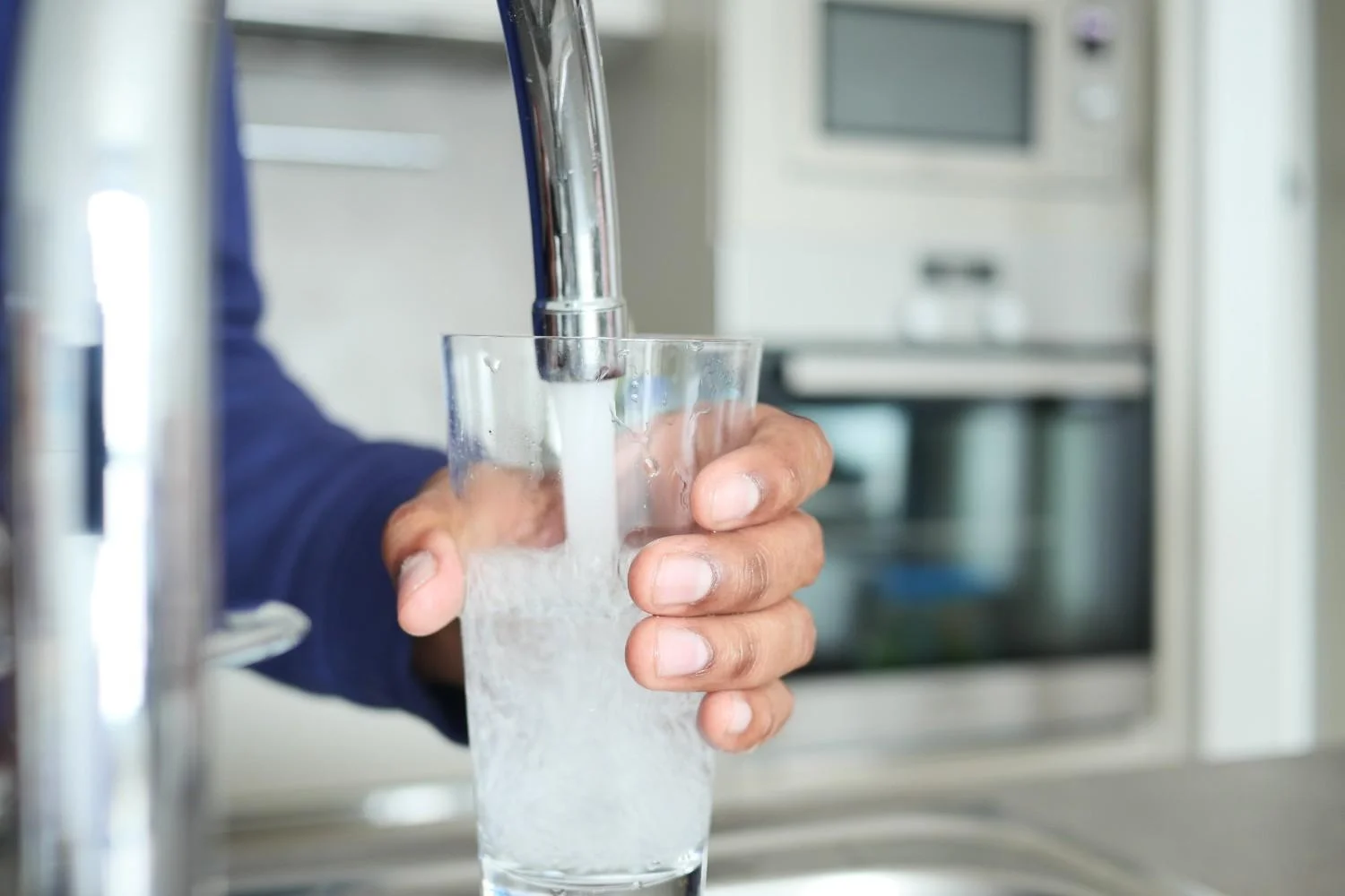 Cloudy tap water in a glass showing signs your tap water may need better filtration